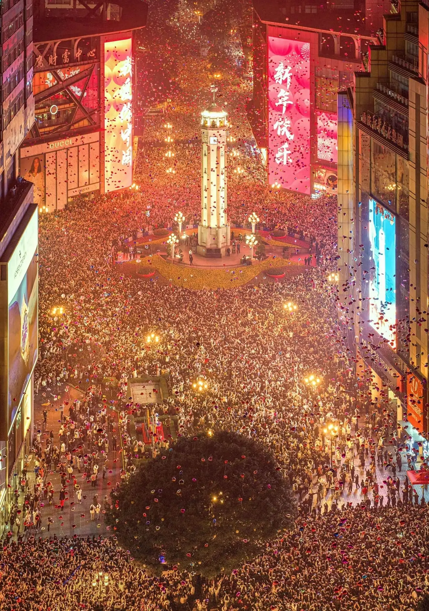 Massive crowds gathering at Jiefangbei square to hear the New Year bell, showcasing Chongqing's festive winter atmosphere.